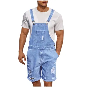 Detailed view of light blue distressed denim overalls shorts with ripped details and metal buckles