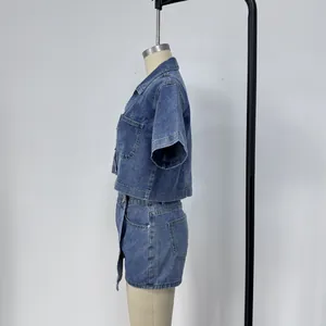 Dettaglio di un set in denim lavato blu con cuciture su camicia a maniche corte e gonna