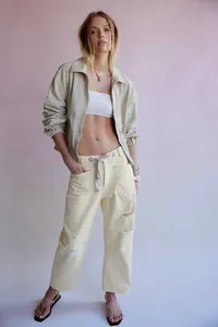 Détail du pantalon taille haute avec des trous usés et une large ceinture à cordon