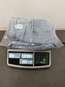 Quality weight check showing loose distressed denim jeans at 739.9g for size XL