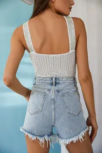 Rear view detail of high-waist denim shorts with distressed fringe and sequin tank top