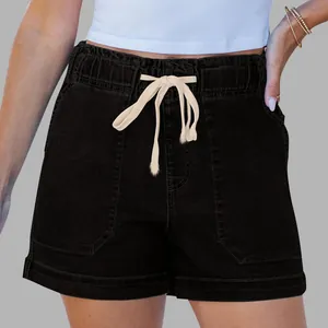 Detail of black denim shorts featuring elastic drawstring waist and large utility pockets