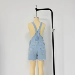 Rear view of denim overalls featuring cross-back straps, distressed holes, and raw hems