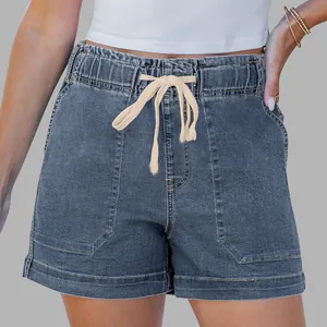Detail of high waisted dark blue denim shorts with elastic waist and cream drawstring
