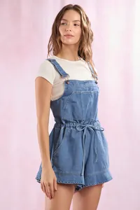 Close-up of light blue wash denim overalls with waist drawstring and chest pocket