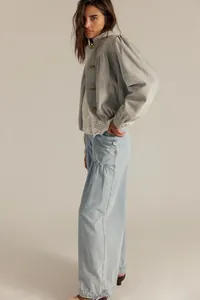 Dettaglio dei jeans azzurri a vita alta e gamba larga con dettagli di cuciture orizzontali