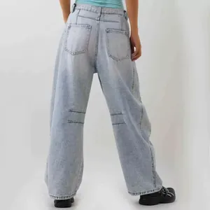 Detail of light blue wide-leg jeans with back pockets and unique horizontal stitching