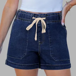 Detailed view of dark blue denim shorts featuring elastic waist and beige drawstring cords