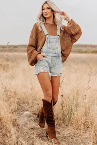 Outdoor look featuring a hollow brown knit sweater and light blue ripped denim overalls