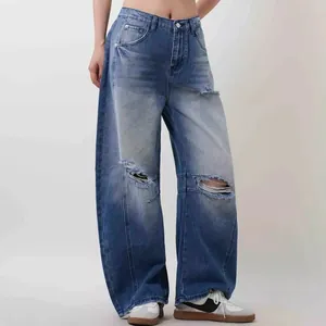 Macro detail of high-waist wide-leg jeans with vintage wash and distressed knee cutouts