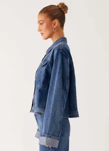 Detail of mid-blue washed denim jacket and jeans set with classic lapel and chest pocket