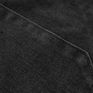 Detailed macro view of dark grey twill denim fabric with precise stitching details