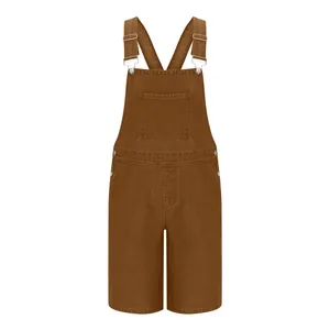 Detail of brown denim overalls with silver adjustable buckles and front utility pocket