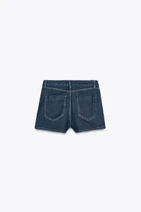 Vista posteriore di shorts in denim blu scuro con cuciture bianche e tasche posteriori