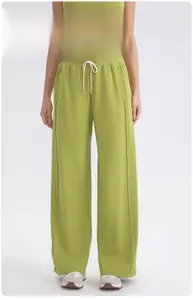 Detalle de los pantalones de yoga verdes de cintura alta con cordón blanco y costura central