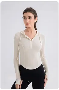 Detail of slim-fit hooded yoga top featuring ribbed texture and half-zip design