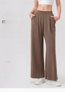 Detail of high-waist elastic waistband on brown wide-leg yoga pants with side pockets