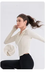 Detail of cream ribbed yoga hoodie featuring textured fabric and adjustable drawstring