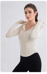 Detail of slim-fit ribbed hooded yoga shirt featuring a half-zip and high elasticity