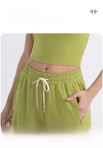 Detalle del pantalón de yoga verde aguacate con cordón blanco y tejido suave de algodón