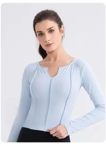 Détail d'un haut de yoga bleu clair ajusté avec col rond échancré et coutures de renfort