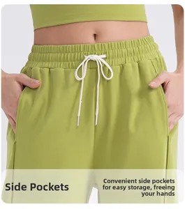 Detalle de pantalones de yoga de cintura alta con bolsillos laterales y cordón verde