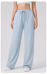 Vue de face du pantalon de yoga taille haute bleu clair à jambes larges et cordon