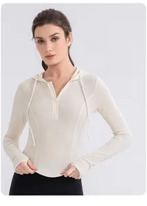 Detail of cream long-sleeve hooded yoga top with half-zip and thumbhole cuffs