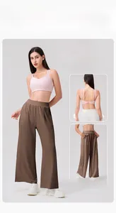Detail view of high-waisted wide-leg athletic pants with side pockets and draped fabric