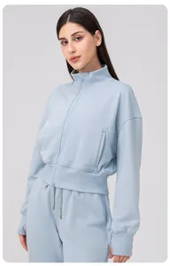 Detail of light blue women's zip-up sports jacket with ribbed cuffs and stand collar