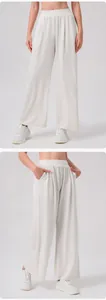Detailed view of elastic high waist pleats and side pockets on off-white wide-leg pants