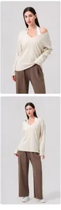 Detailansicht eines cremefarbenen V-Ausschnitt-Yogashirts mit brauner weiter Hose