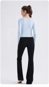 Haut de yoga bleu clair à manches longues et legging noir évasé, vue de l'arrière