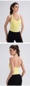Detail of light yellow halter yoga vest and black high-waist leggings on a fitness model