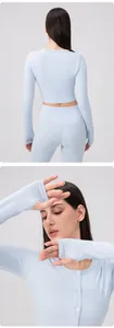 Detailed view of light blue yoga top with front button neck and thumbhole sleeve cuffs