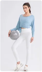 Detail of light blue modal yoga top with waist twist knot design and white high waist leggings