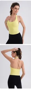 Vertical view of a bright yellow halter yoga vest and black leggings on a fit model