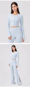 Detail view of light blue yoga cardigan with buttons and flared high-waist fitness pants