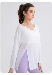 Detailed view of white yoga top with side slits and unique layered neckline design