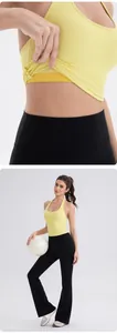 Detail of yellow halter neck yoga vest and black flared sports pants on model