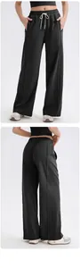 Detalle de pantalones de yoga negros anchos con cordón en cintura y costuras verticales