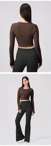 Detail view of brown cropped buttoned yoga top and black flare pants set for workout
