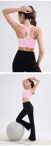 Close-up of pink racerback sports bra and black yoga flare pants on a fitness mat