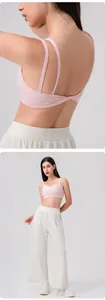 Detail of light pink yoga bra with dual thin straps and twist back design for fitness
