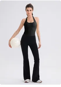 Detail of black halter yoga tank top and high-waisted flared pants on a model in studio