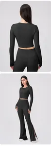Detail of black yoga top featuring thumbhole cuffs and buttoned front for women