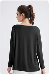 Rear view of loose black modal yoga top featuring a wide neck and breathable fabric
