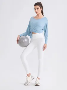 Light blue modal yoga top with cut-out neck and waist knot paired with white leggings