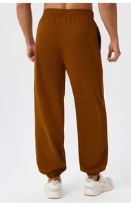 Rear view of caramel brown men's loose joggers with elastic waistband and cuffed ankles