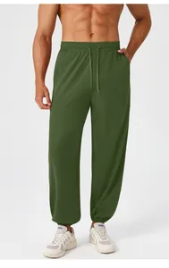 Detail of men's dark green jogger pants with elastic drawstring waist and side pockets